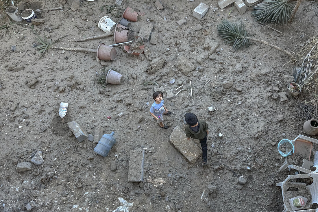 A Palestinian boy looks up from rubble.