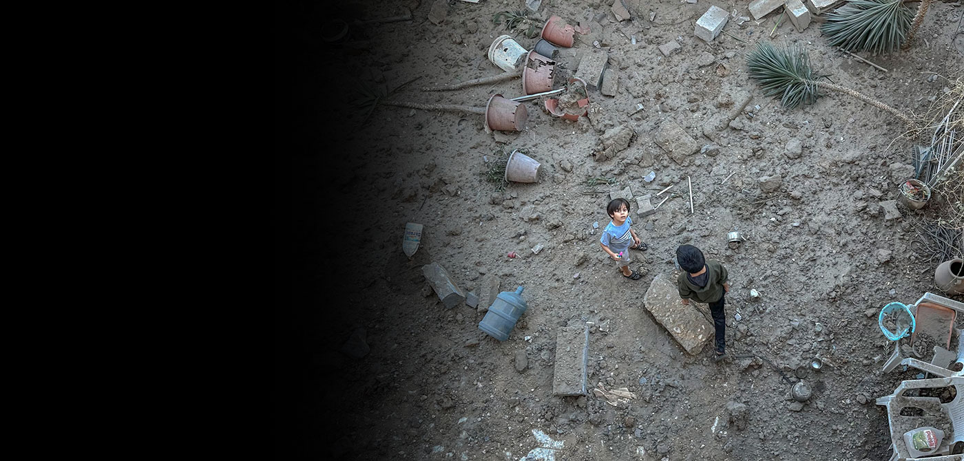 A Palestinian boy looks up from rubble.